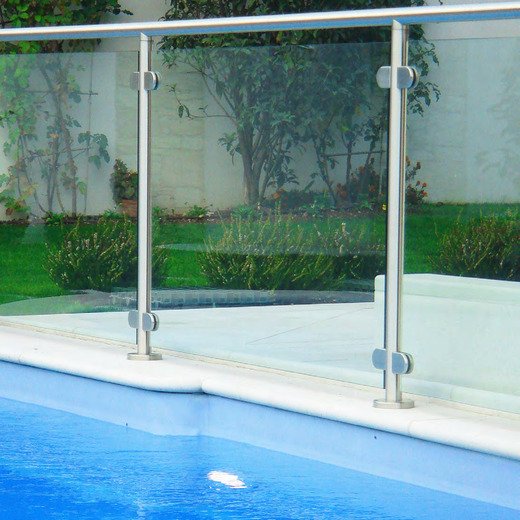 Guarda-corpos de vidro com pinças em inox junto a uma piscina